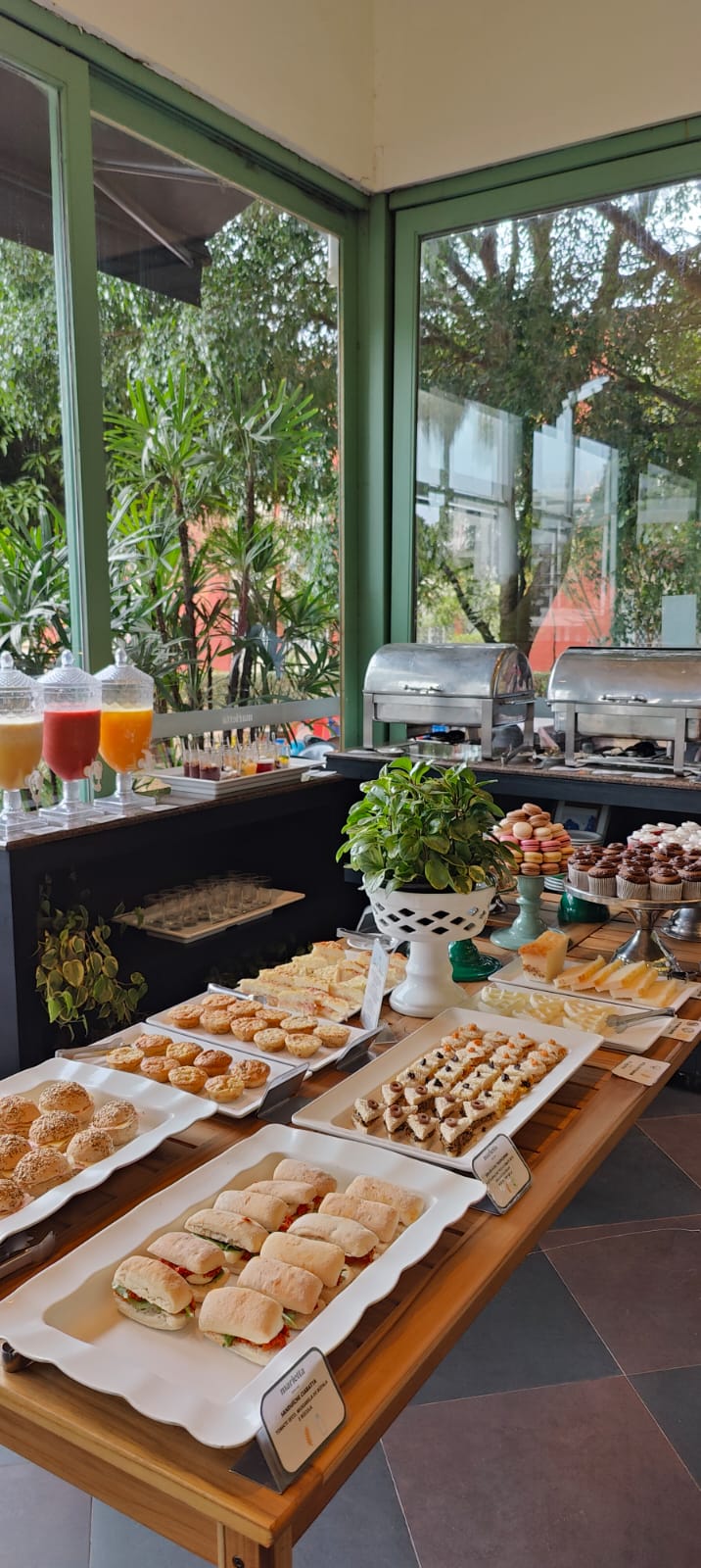 Buffet completo com sucos, pães, doces e salgados servidos na varanda do Marietta